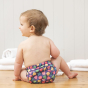 Toddler sat on the floow wearing the Totsbots mussel sea shell eco-friendly reusable swimming nappy