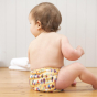 Toddler sat on the floor wearing the Totsbots surfs up eco-friendly reusable swimming nappy 