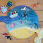Toys by Nature eco-friendly wooden play base on a wooden floor, covered in wooden toys to make an ocean scene