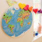 Waldorf family eco-friendly large wooden globe hanging on a white wall next to a window