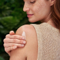 A person applying the Weleda Skin Food original to their shoulder