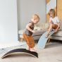 Young children playing on a Wobble Beech Wood Starter wobble board and Wobble Board Felt in a living room