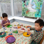 Two boys playing with mandala pieces in front of the Wonder Cloths eco-friendly large playing cloth