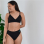 Woman stood wearing the WUKA everyday bikini brief eco-friendly pants on a grey background