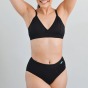 Woman stood on a grey background wearing the eco-friendly WUKA tencel midi underwear