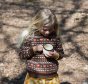 Girl wearing LGR brown autumn foxes snuggly jumper holding a mug in the woods