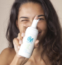 woman holding the bottle of green people organic foaming cleanser wash