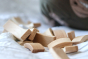 Close up of a pile of Abel plastic-free wooden Golden Ratio toy blocks on a white bed
