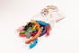 Alphabet Jigsaw handmade Rainbow arch children's puzzle pieces pouring out of a white drawstring bag on a white background