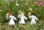 Ambrosius handmade felt chamomile fairy figures with white, light brown and black skin in some long grass