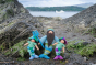 Ambrosius King Neptune and the blue and purple mermaid collectable dolls balanced on some rocks in front of the ocean