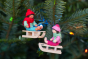 Ambrosius collectable felt sledging boy and girl Christmas decorations hanging from a Christmas tree