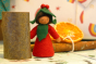 Ambrosius collectable holly crown fairy figure on a white table in front of a dried orange slice and small wooden log