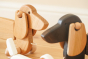 Close up of the Bajo natural wooden pull along dachshund toy dog next to the dark oak Bajo dachshund toy
