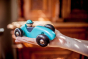 Bajo Wooden Toy Steering Racing Car - Blue in an adult hand for scale