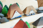 Close up of the Bumbu Bucovina eco-friendly wooden house toys next to a Kapla wooden block and some grapat mandala trees