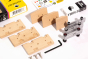 Pieces of the Candylab diy wooden car building toy set spread out on a white background