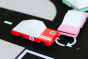 Close up of the Candylab red racing car and pink sedan diecast toys on a black toy road set