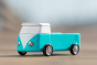 Close up of the candylab handmade wooden blue beach campervan toy on a beige background