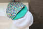 Close white breast pads on a white sink next to the Close eco-friendly brights print pad pouch