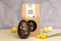 Cocoa Loco fairtrade dark chocolate and ginger easter egg on a beige worktop next to some mini easter eggs and a daffodil