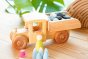 Debresk handmade solid wood dump truck on a wooden table next to some wooden figures and filled with wooden counters