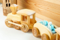 Debresk eco-friendly solid wood train set filled with Grapat mandala pieces next to a natural wooden wall