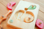 Drei Blatter eco-friendly wooden apple puzzle pieces scattered on a wooden background