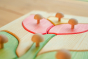 Close up of the Drei Blatter wooden flower puzzle pieces on a wooden background