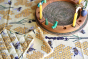 Duns Sweden organic cotton pot holder and tea towel in the bee yellow print on a tablecloth next to a celebration ring