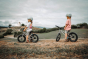2 children sat on their Early rider 14 inch seeker trail bikes in a grassy field
