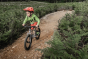 Young boy riding the Early Rider seeker trail bike on a gravel track