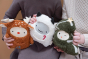 Close up of two children's hands holding the Fabelab organic cotton Fabbie yeti, reindeer and Christmas tree toys