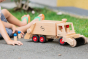 Close up of child pushing the Fagus large garbage truck toy with the sweeper attachment on the front