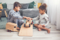 Two children playing with the Fagus modern tractor and wooden horse box toy on a wooden balance board in a grey living room