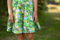 Close up of the bottom of the Frugi Hedgerow print Spring Skater Dress worn by child