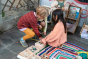 2 children crouched down reaching into the Grapat wooden permanence toy box