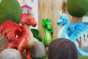 Close up of the Green rubber toys eco-friendly dragons stood between some papoose rock toys