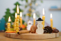 Grimm's 16-Hole Natural Wooden Celebration Ring with beeswax candles and snowman decorative figure in a Christmas display 