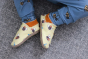 Inch Blue Leather Baby Shoes - Bee Happy Lemon worn by a child with bee printed blue joggers on a grey rug