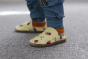 Inch Blue Leather Baby Shoes - bee happy yellow worn by a child wearing blue joggers with bee prints, stood on a grey carpet