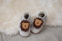 Inch Blue Leather Baby Shoes - Leo Cream on wooden flooring and a cream fluffy rug