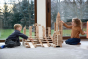 Two children playing with the Just Blocks Smart Lines set stacked in the shape of a big building on a grey carpet