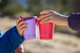 Close up of 2 childrens hands holding up some Klean Kanteen 10oz steel sippy drinks cups 