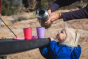 Child looking up at some hands pouring water from a Klean Kanteen TKPro into some Kid Kanteen 10oz steel sippy cups