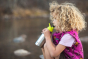 Girl drinking from a stainless steel kids Klean Kanteen bottle with a green sports drink cap 