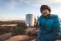Woman sat on a rock holding up the Klean Kanteen eco-friendly stainless steel camping mug