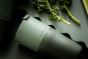 Close up of a Klean Kanteen stainless steel 26oz tumbler on a dark green background next to some green vegetables