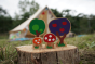 Close up of the Lanka Kade Babipur eco-friendly wooden toadstool and tree toys on a wooden log in front of a beige tent