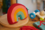 Close up of the Little Green Radicals over the rainbow cuddly soft toy on a wooden stand